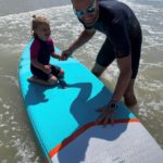 homme avec petite fille sur un paddle dans la mer