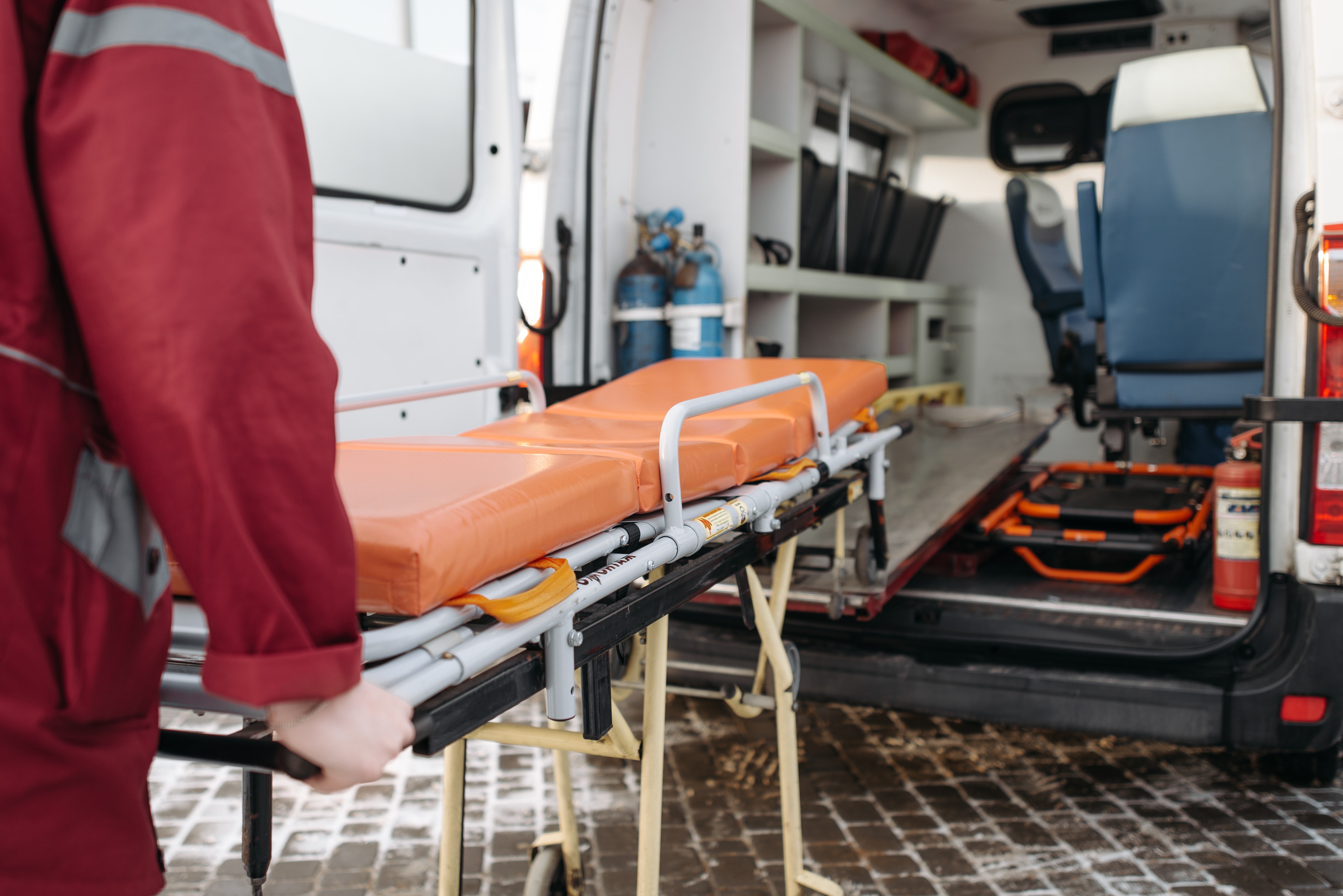 infirmier poussant un brancard dans une ambulance